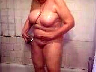 Природна възрастна жена с големи гърди се къпе добре