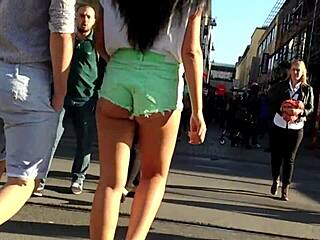 אישה צעירה ומושכת במכנסיים קצרים מטיילת במורד הכביש
