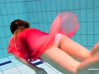 La belle russe Duna nage dans une piscine tout en portant un bikini