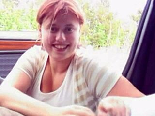 En ung rødhåret smuk fed kvinde i en bil